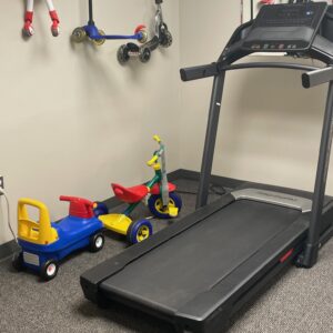 Pediatric therapy equipment at Good Beginnings Therapy in Falls Church, VA, including a treadmill and ride-on toys used during occupational and physical therapy sessions to support balance, coordination, and motor development.